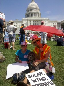 mom and daughter sitting on the grass at Stop the Frack Attack rally