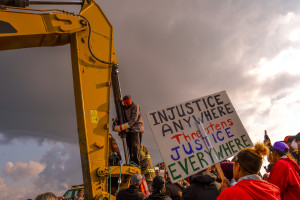 Happy American Horse attaching himself to an excavator at the construction site of the Dakota Access Pipeline on 31 August 2016. Photo by Rob Wilson for Bold Alliance